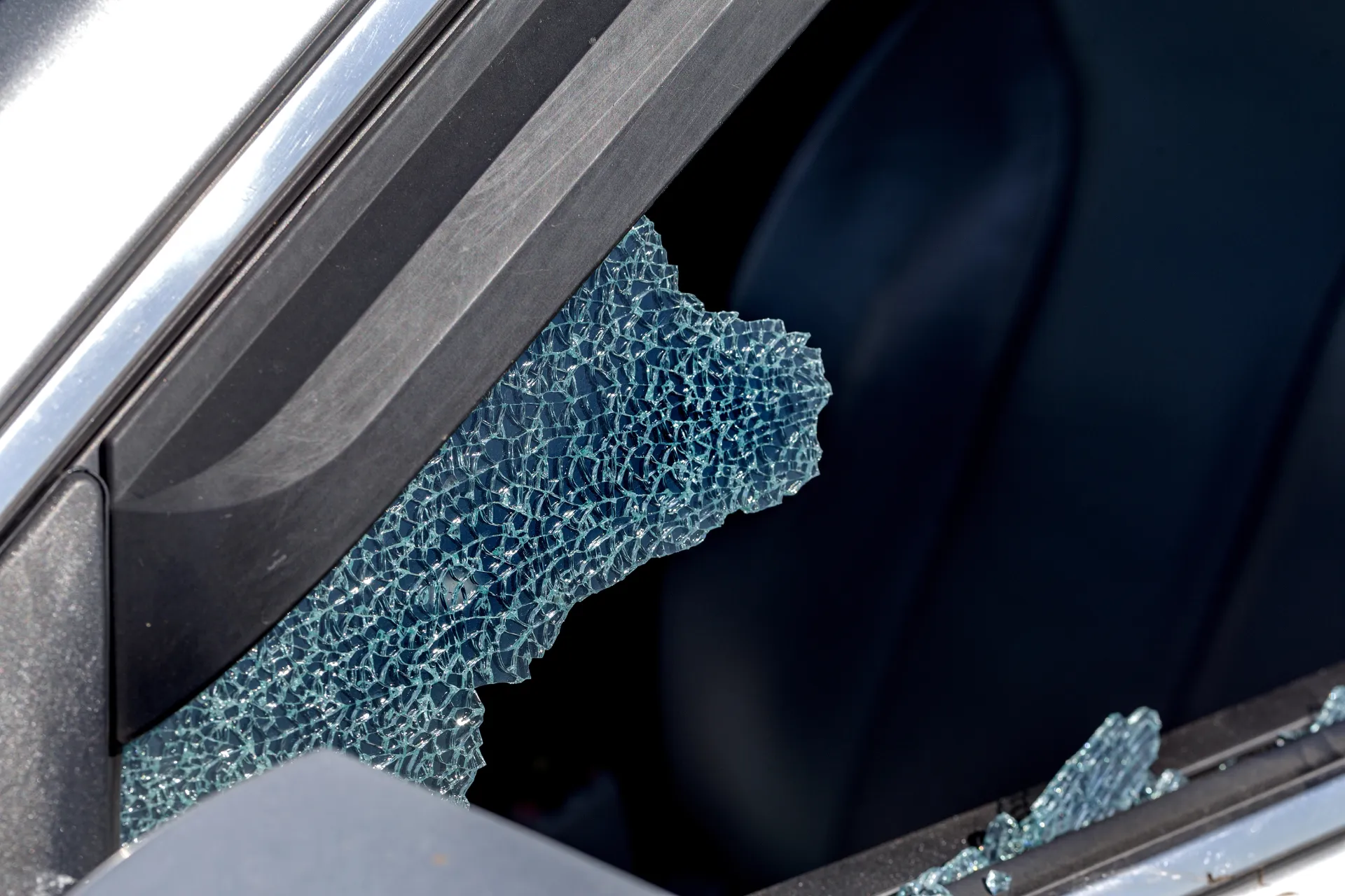 Vitres latérales d'une voiture brisées avec des éclats de verre visibles, semblant provoquer des dommages au pare-brise à Lorient