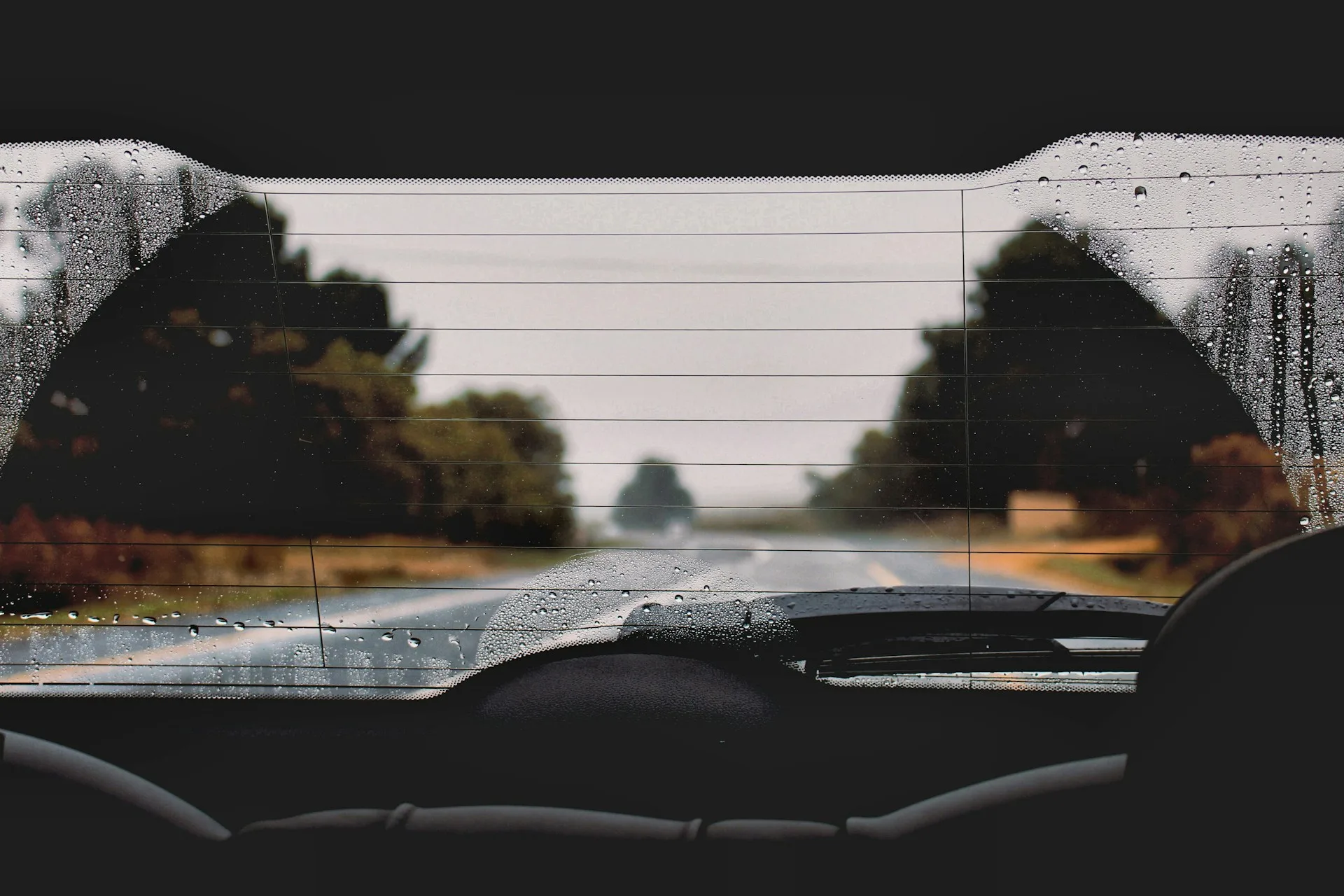 Buée et condensation sur une vitre de voiture sous la pluie