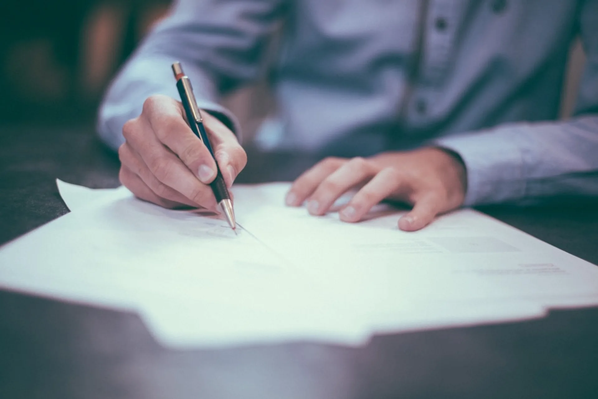 Personne remplissant un document d'assurance à la main